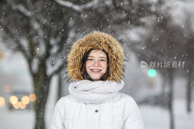 雪下穿着白色夹克的漂亮少女