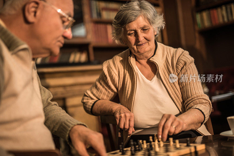 一对老夫妇在家里休息下棋。