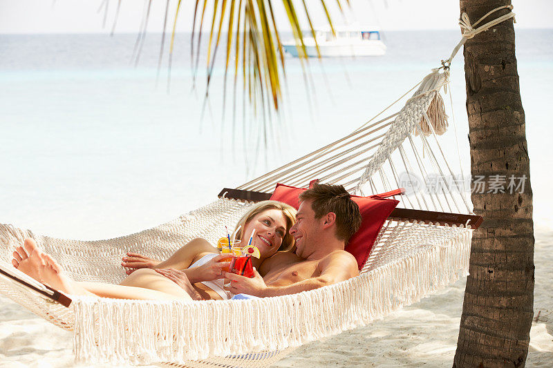 浪漫的情侣在沙滩吊床上放松