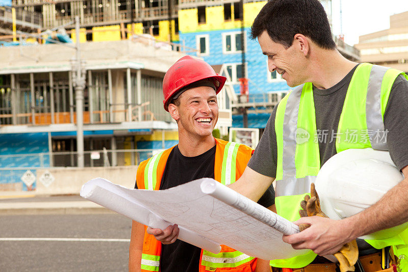 两个建筑工人在看建筑图则。