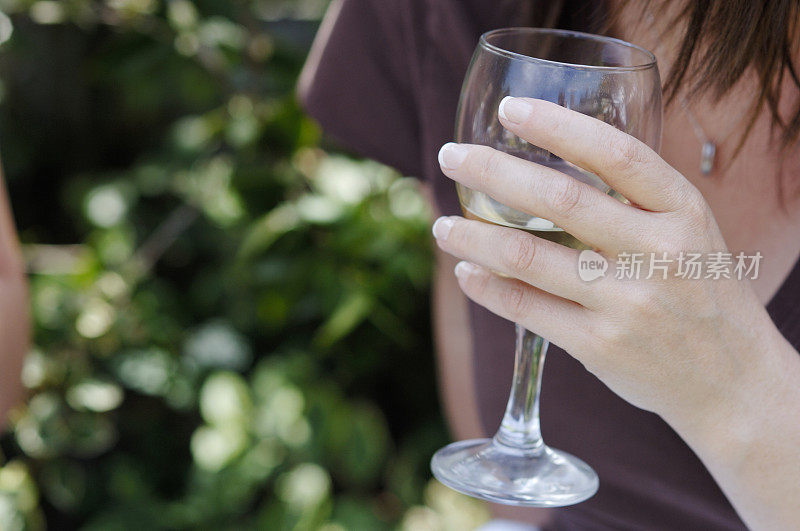 在夏日的花园里，女士们手握酒杯