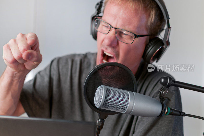 愤怒的电台主持人或播客主播在办公桌前工作