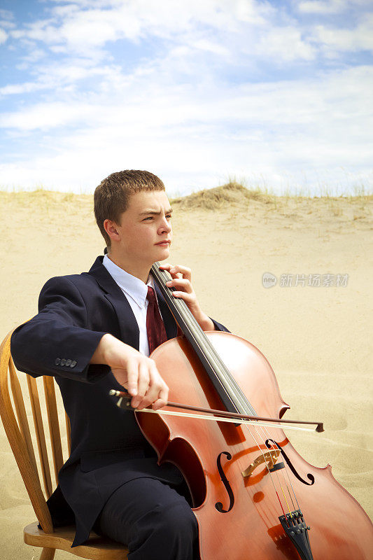 一个年轻人在沙漠里拉大提琴