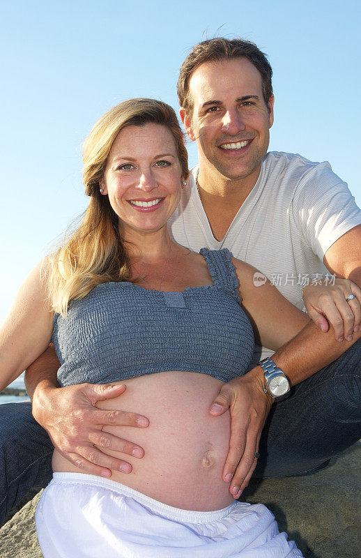 幸福的夫妇与丈夫的手在妻子怀孕的肚子