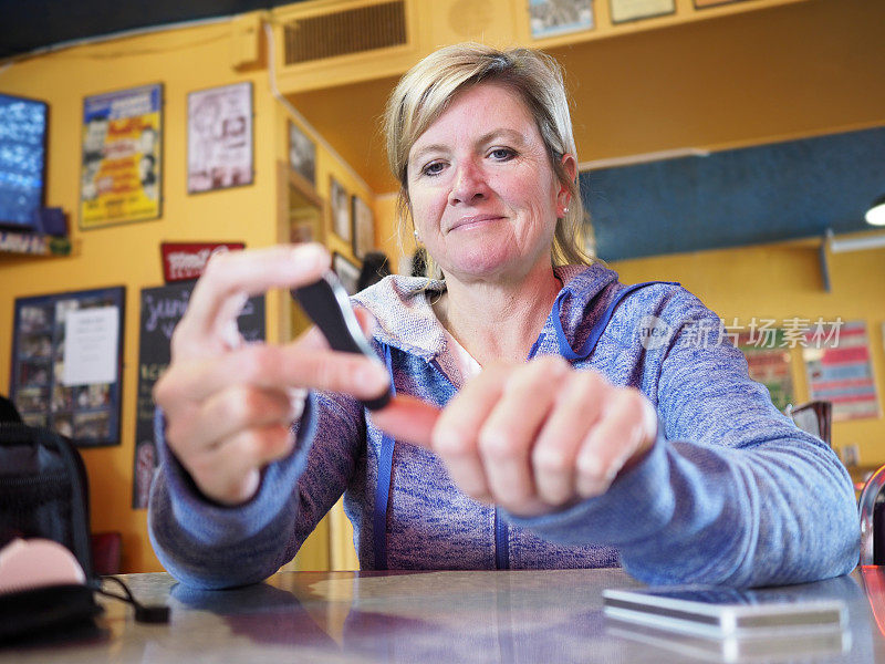 一位糖尿病妇女在餐厅检查血糖