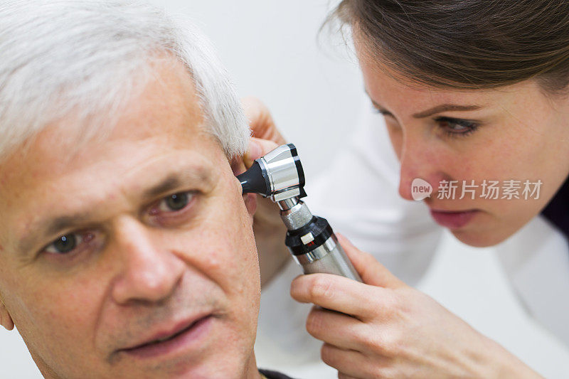 年轻女医生用耳镜检查病人的耳朵