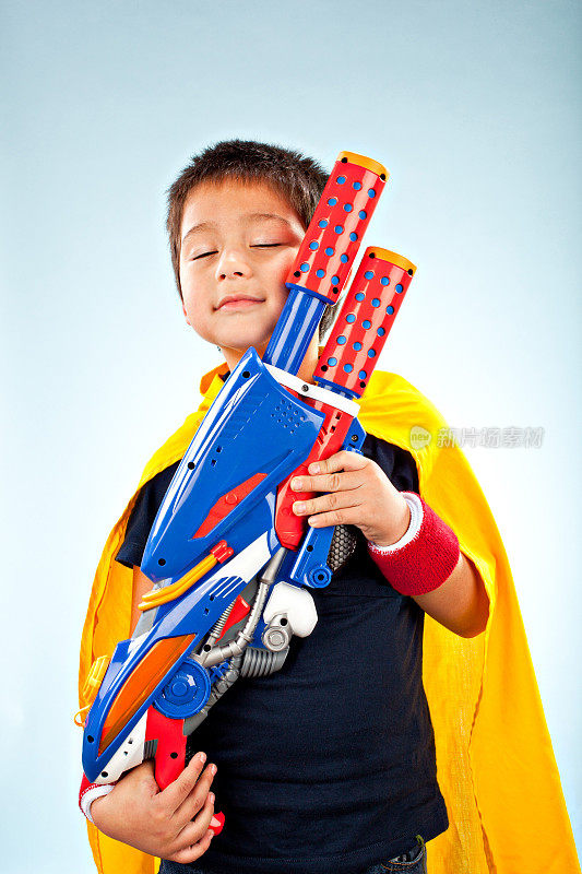 超级英雄男孩抱着他的枪