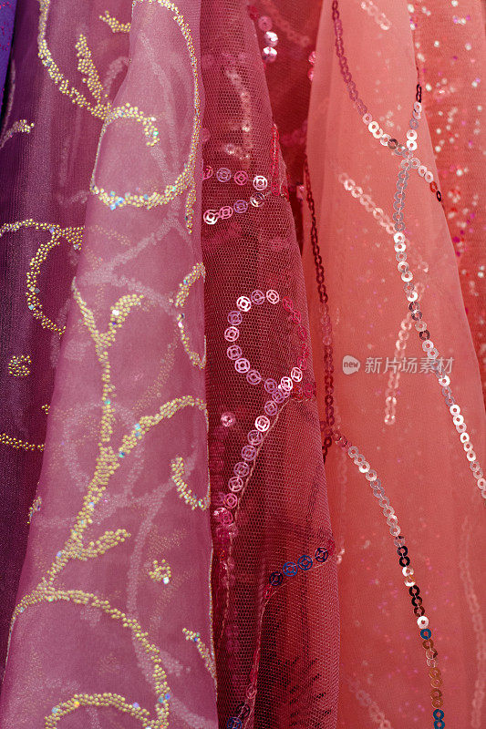 花哨的亮粉色和橙色的印度织物排列