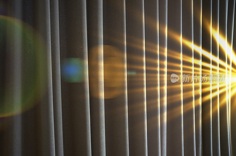 强烈的光线照射在窗帘上，伴有镜头光晕