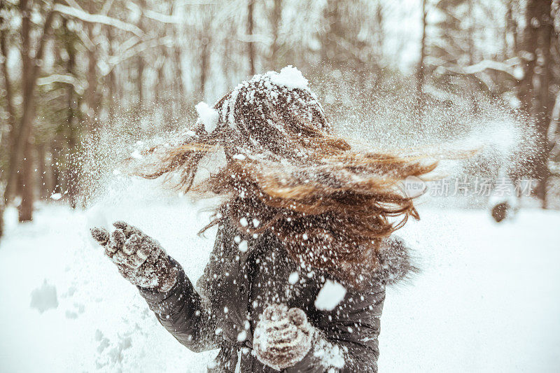 十几岁的长发女孩玩雪