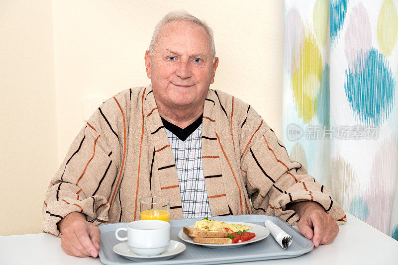 老男人坐在桌边吃饭