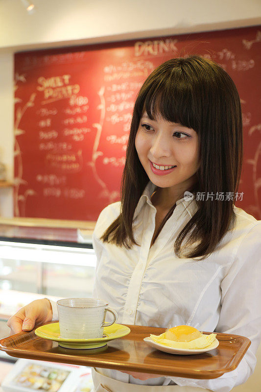 日本咖啡馆的年轻漂亮的女服务员