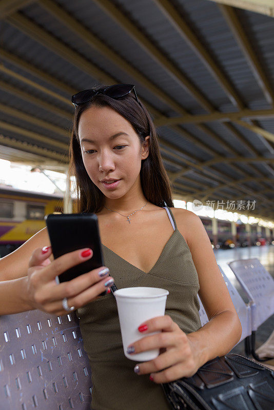 年轻美丽的多民族女游客的肖像在火车站华兰芳在泰国曼谷