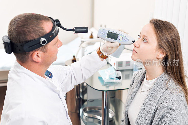 耳鼻喉科专家。非常细心的医疗工作者看着他的来访者的鼻子