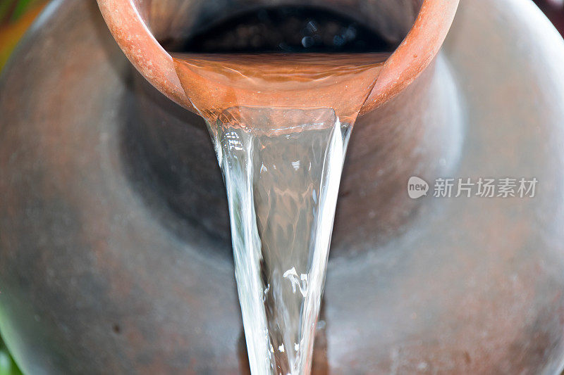 把水从陶土盆里倒出来。
