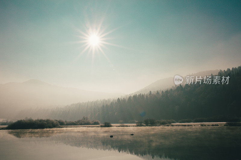 在斯洛文尼亚中部，一个初冬的早晨在背光下拍摄的神秘的湖