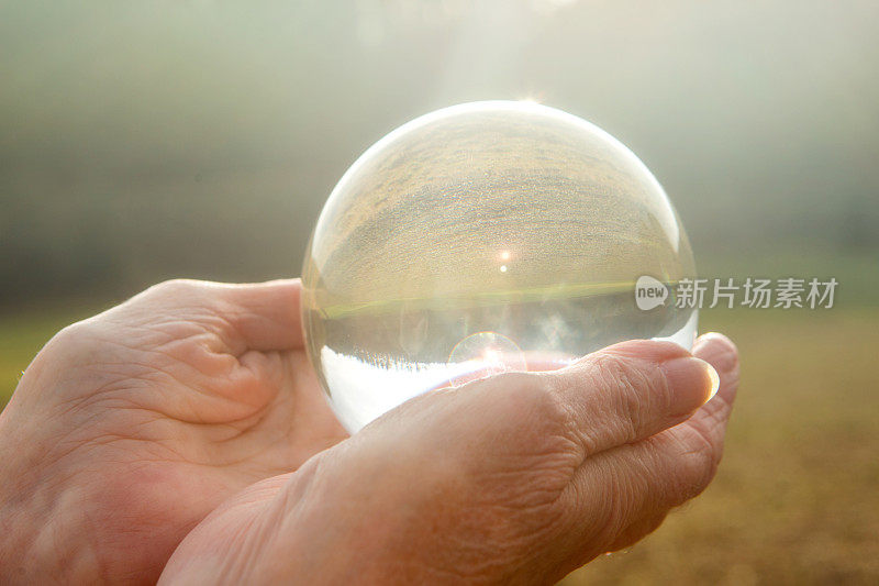 老妇人手里拿着一个发亮的玻璃球