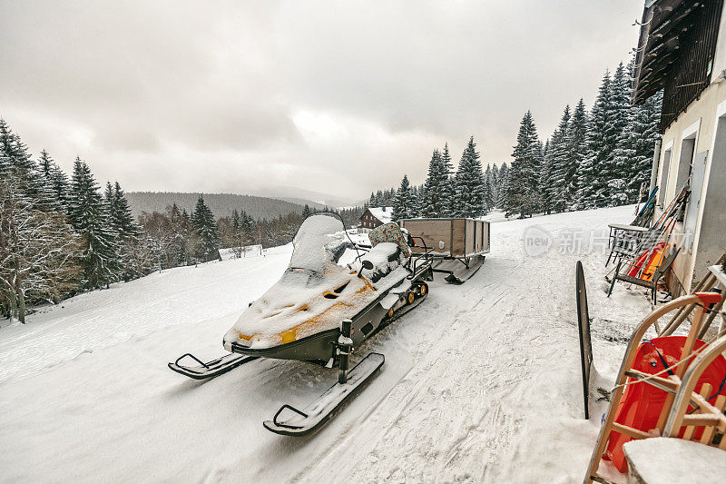 雪地车前的山小屋在大山中