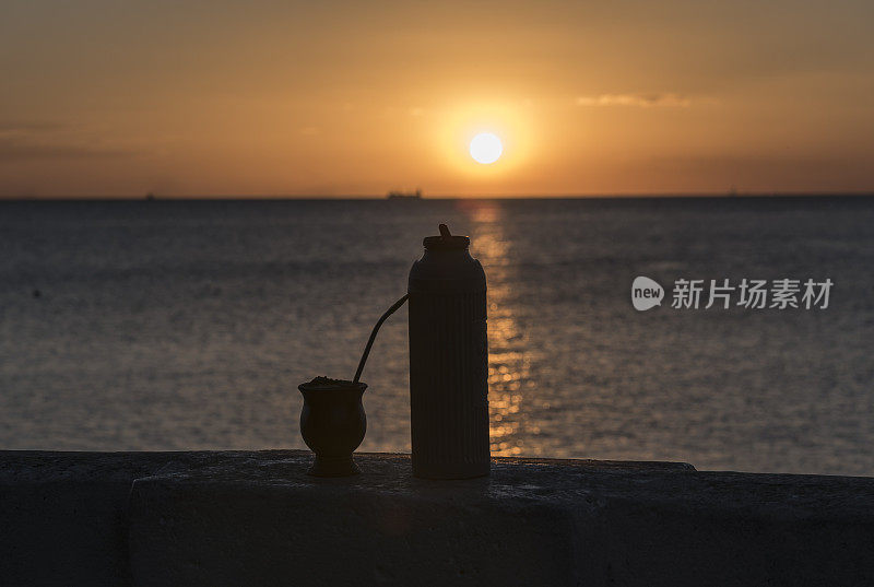 海滩上的日落，伴着家电和葫芦的剪影。