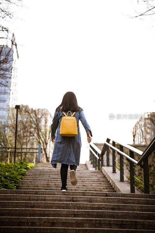 年轻女孩走在楼梯上，向上移动