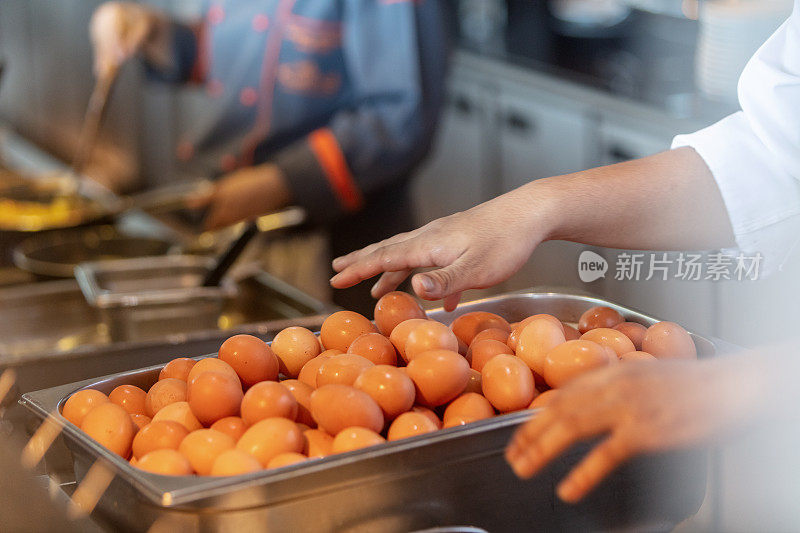 在厨房准备食物的人的中间部分