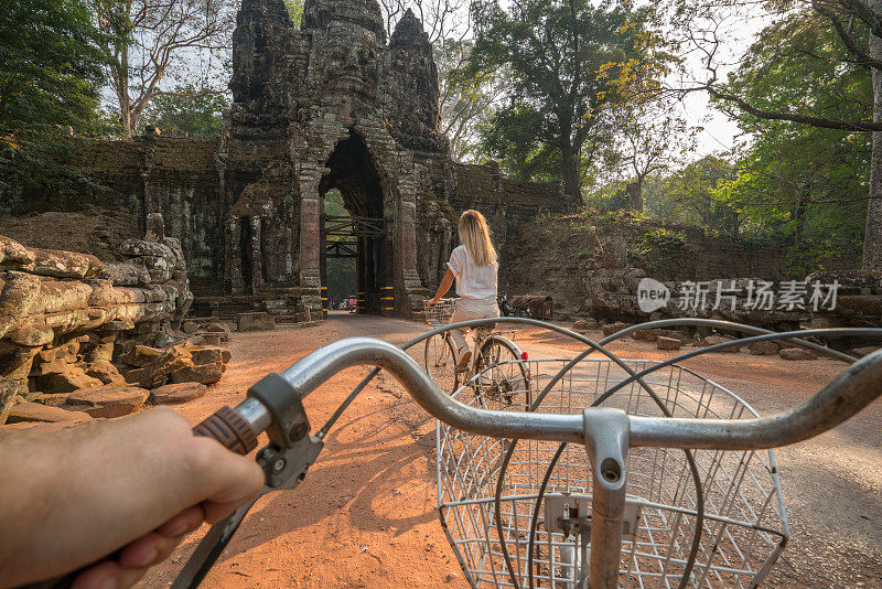 日落时分在亚洲寺庙里骑自行车的夫妇的观点