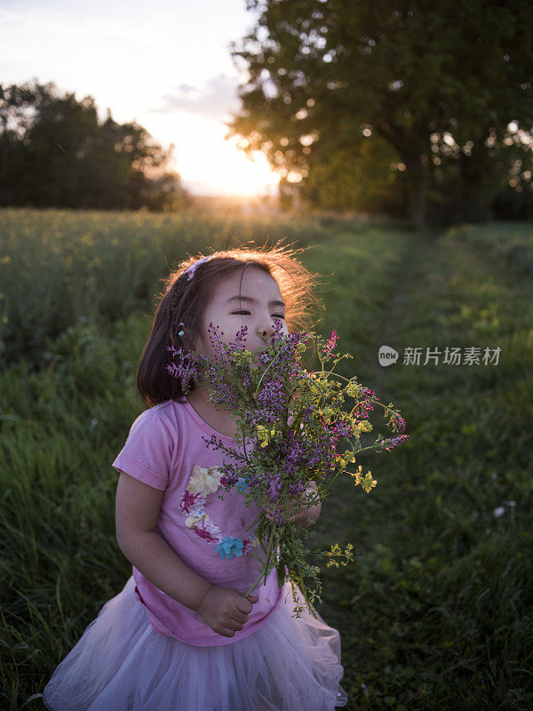 在瑞士闻着夏日鲜花的小女孩