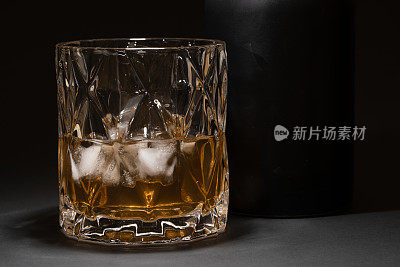 黑色的桌子上放着威士忌水晶杯