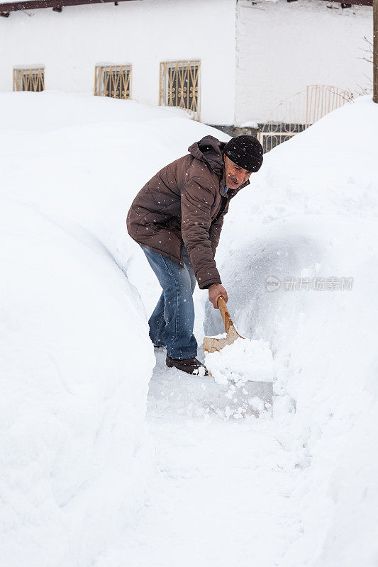 成年男子清扫积雪