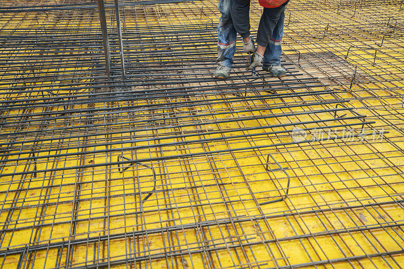 工人在建筑工地为钢筋安装绑扎线