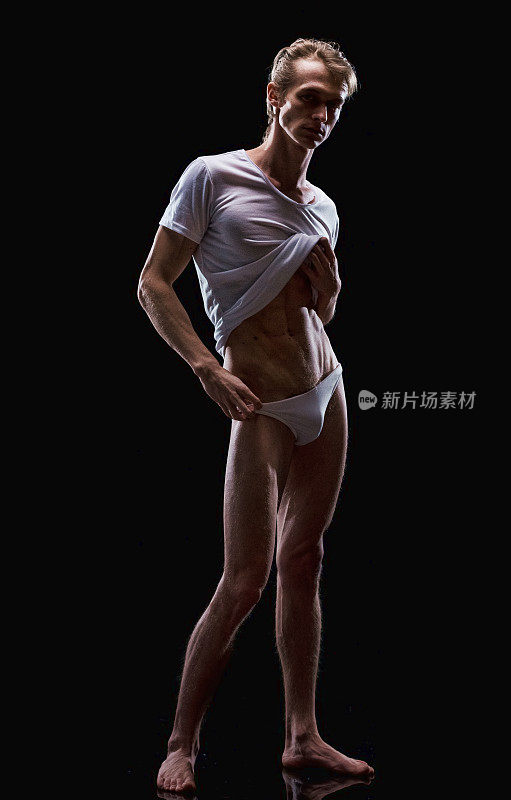 白人年轻男性脱衣舞娘前面的黑色背景穿着衬衫