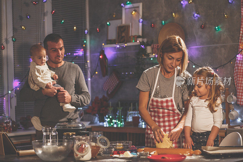 一对父母和他们的孩子在现代家庭厨房做饼干