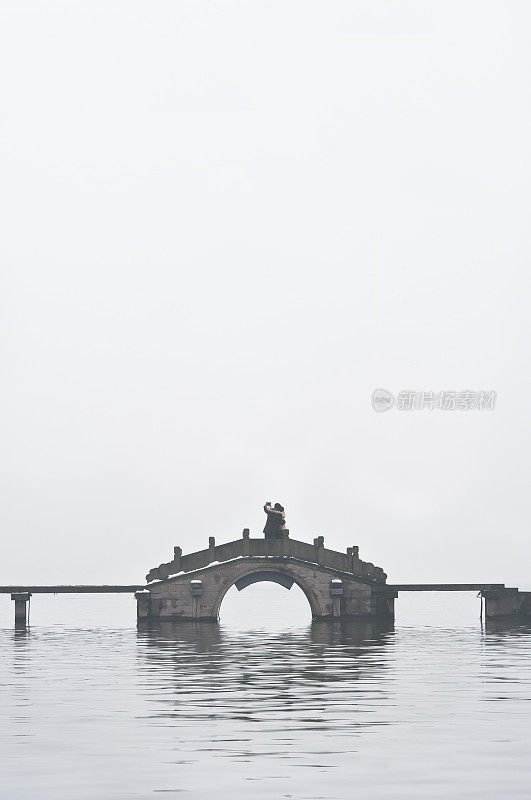 杭州西湖的拱桥和雾中的情侣
