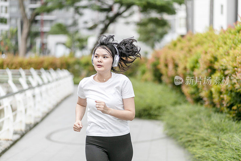 一个年轻女子在公园里跑步和锻炼