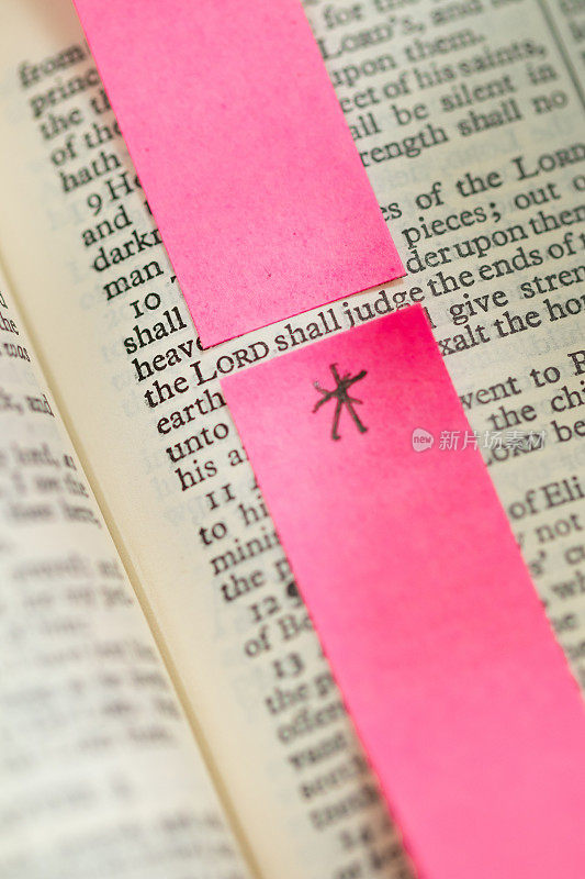 近距离放大的《圣经》页面，上面用粉色贴纸突出了“上帝会审判”的字样