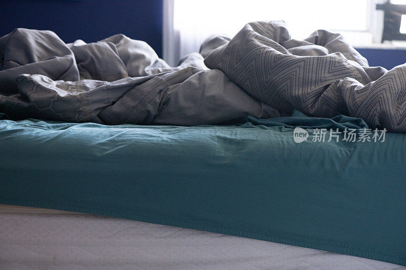 冠状病毒居家期间，蓝色卧室室内凌乱凌乱的床