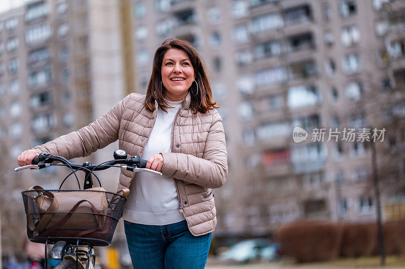 在住宅区里骑着自行车走路的妇女