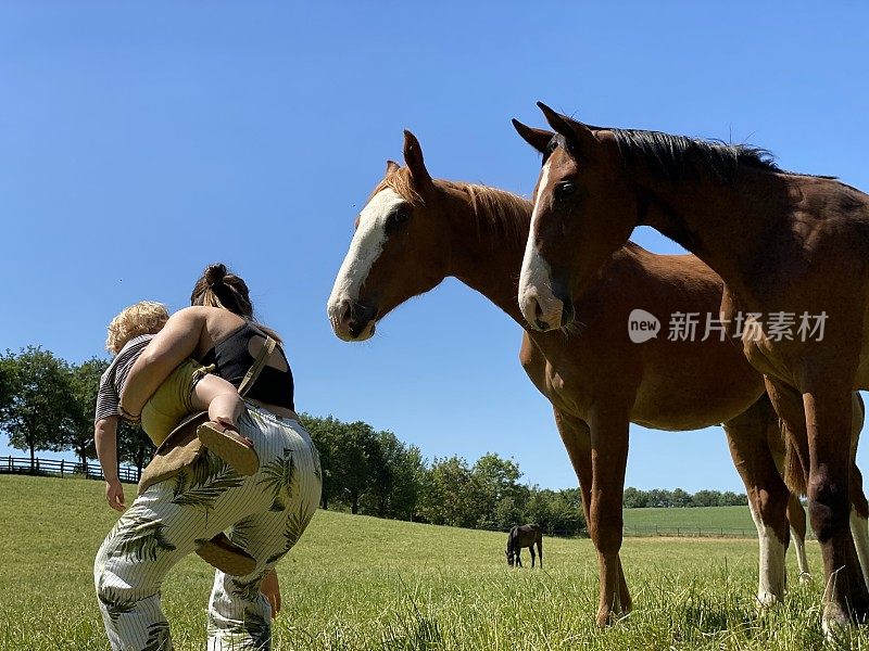 母亲带着小儿子骑着马