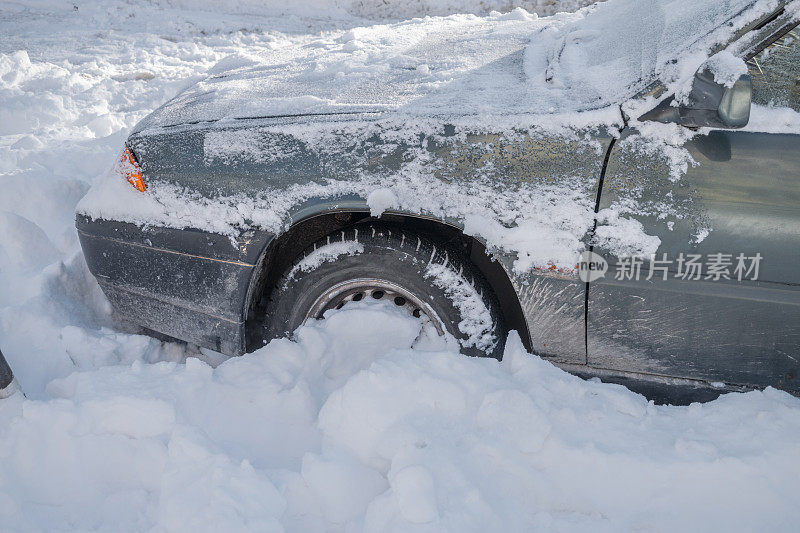 汽车的前轮陷在雪堆里了。雪漂移。