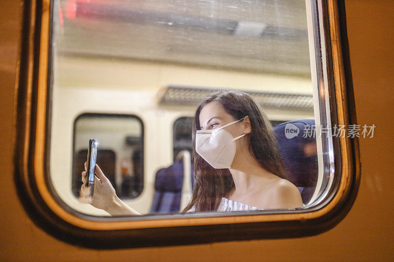 冠状病毒爆发期间，戴着医用口罩的女子乘坐地铁通勤。Covid-19大流行期间，女性乘坐地铁。