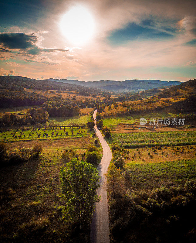 鸟瞰图的乡村景观与蜿蜒的道路和日落