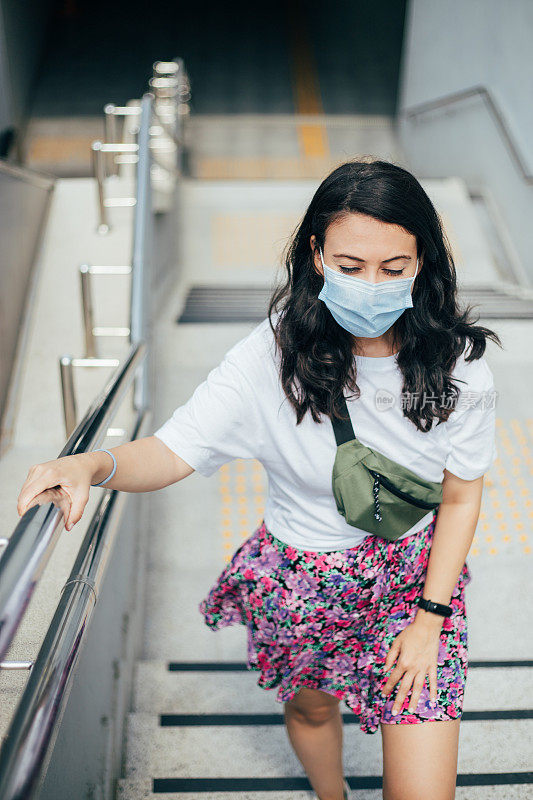 戴着消毒口罩离开地铁站的女病人