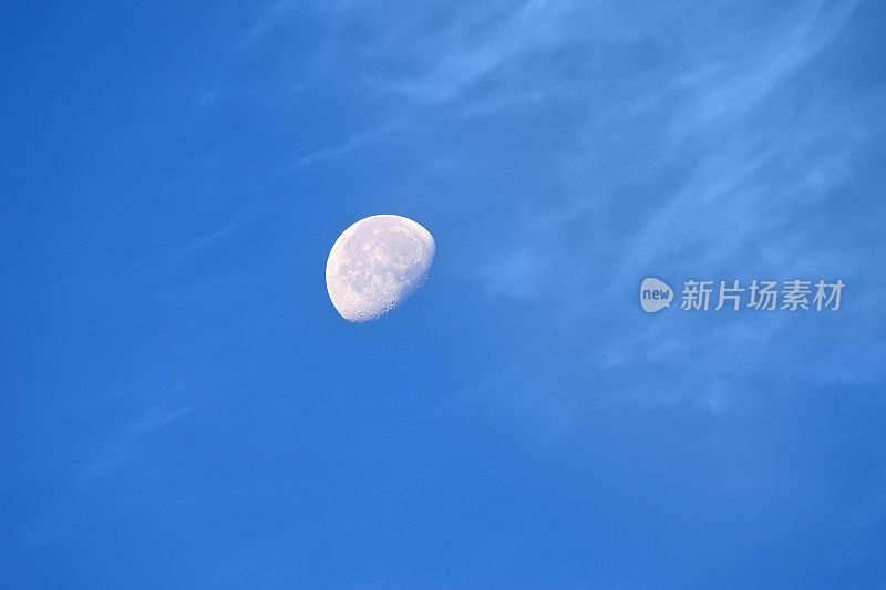 白天的月亮和清澈的蓝天。