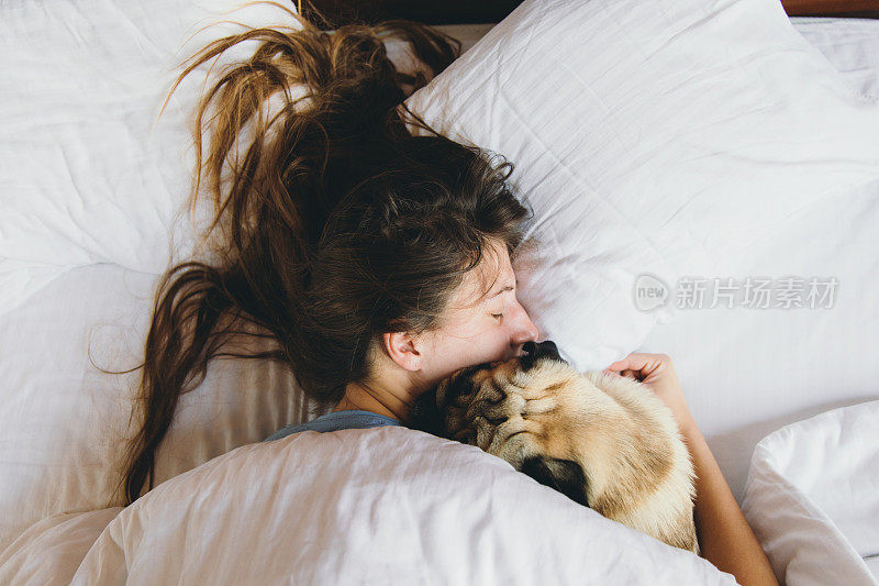 一个女人拥抱着她的小狗的温馨早晨