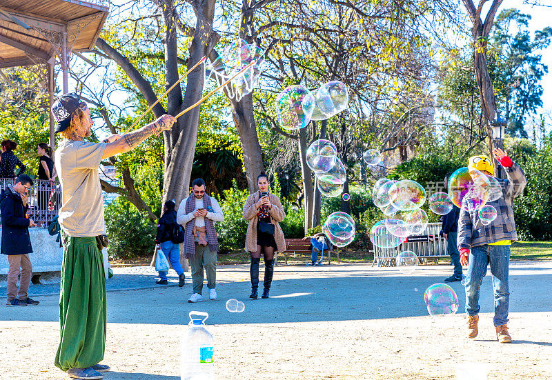 街头艺术家为孩子们制作了一个肥皂泡表演，以接受父母的捐赠。在西班牙巴塞罗那ciutadella公园