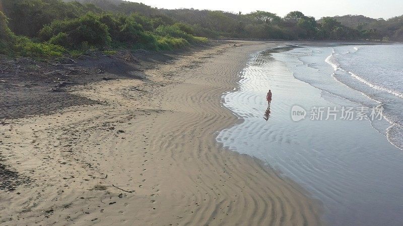 鸟瞰图的女人走下沙滩在日出