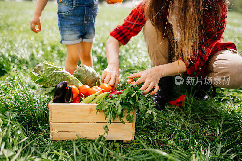 母亲和女儿在农场里吃新鲜蔬菜