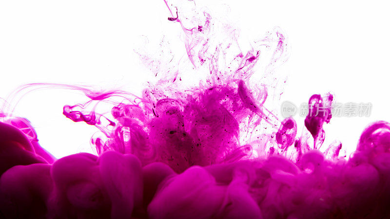 墨水滴在水里。抽象的背景。粉红色的背景。