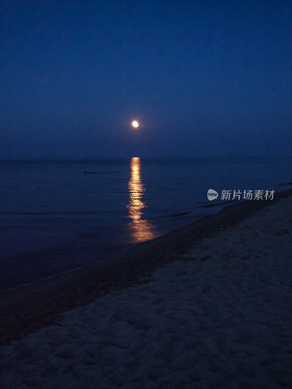 黄昏在海滩与美丽的月亮反射。