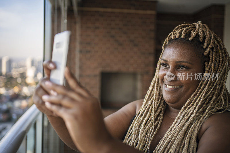 非裔美国美女用智能手机进行在线约会视频通话。